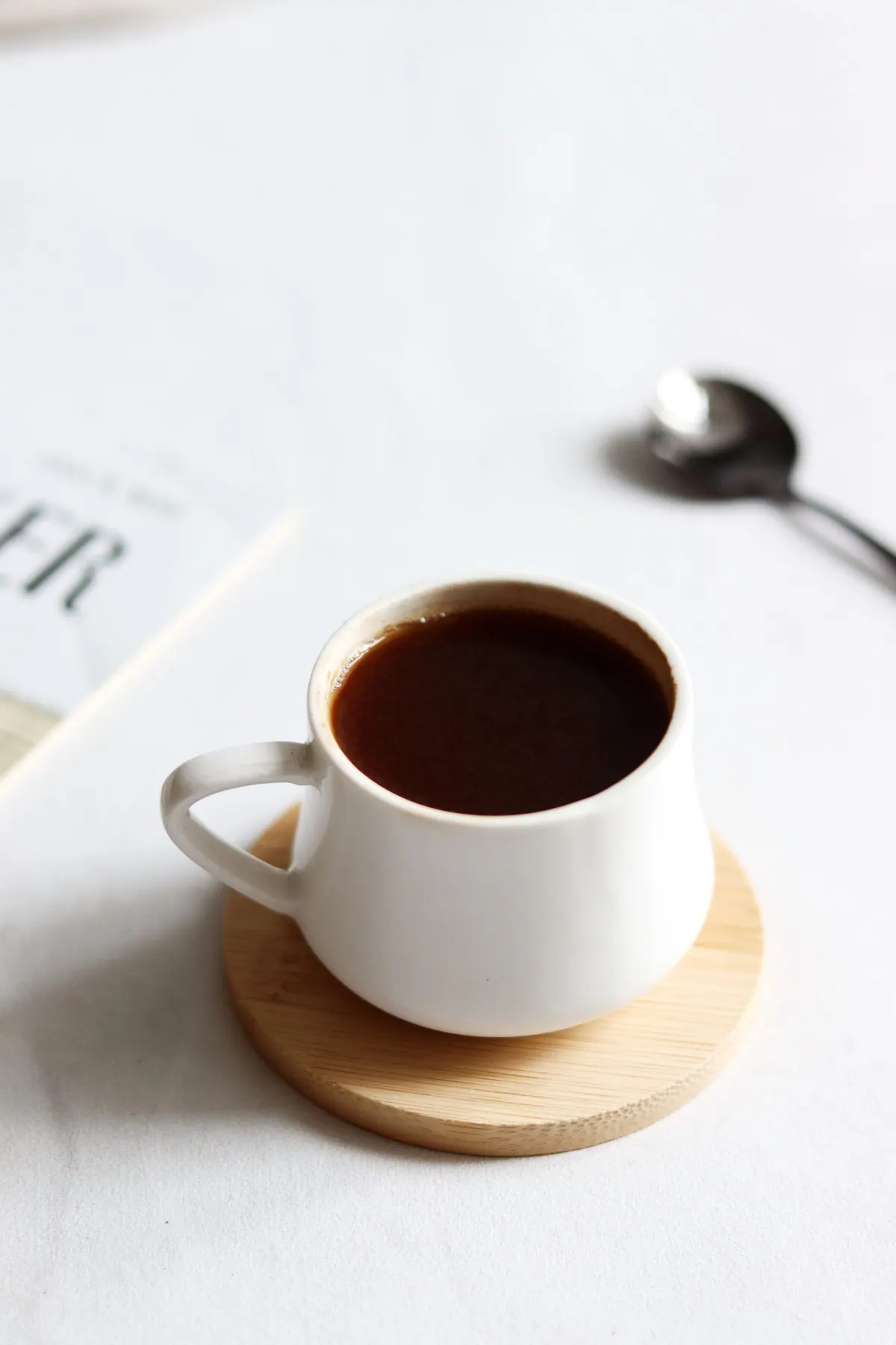A cup of coffee resting on a wooden coaster