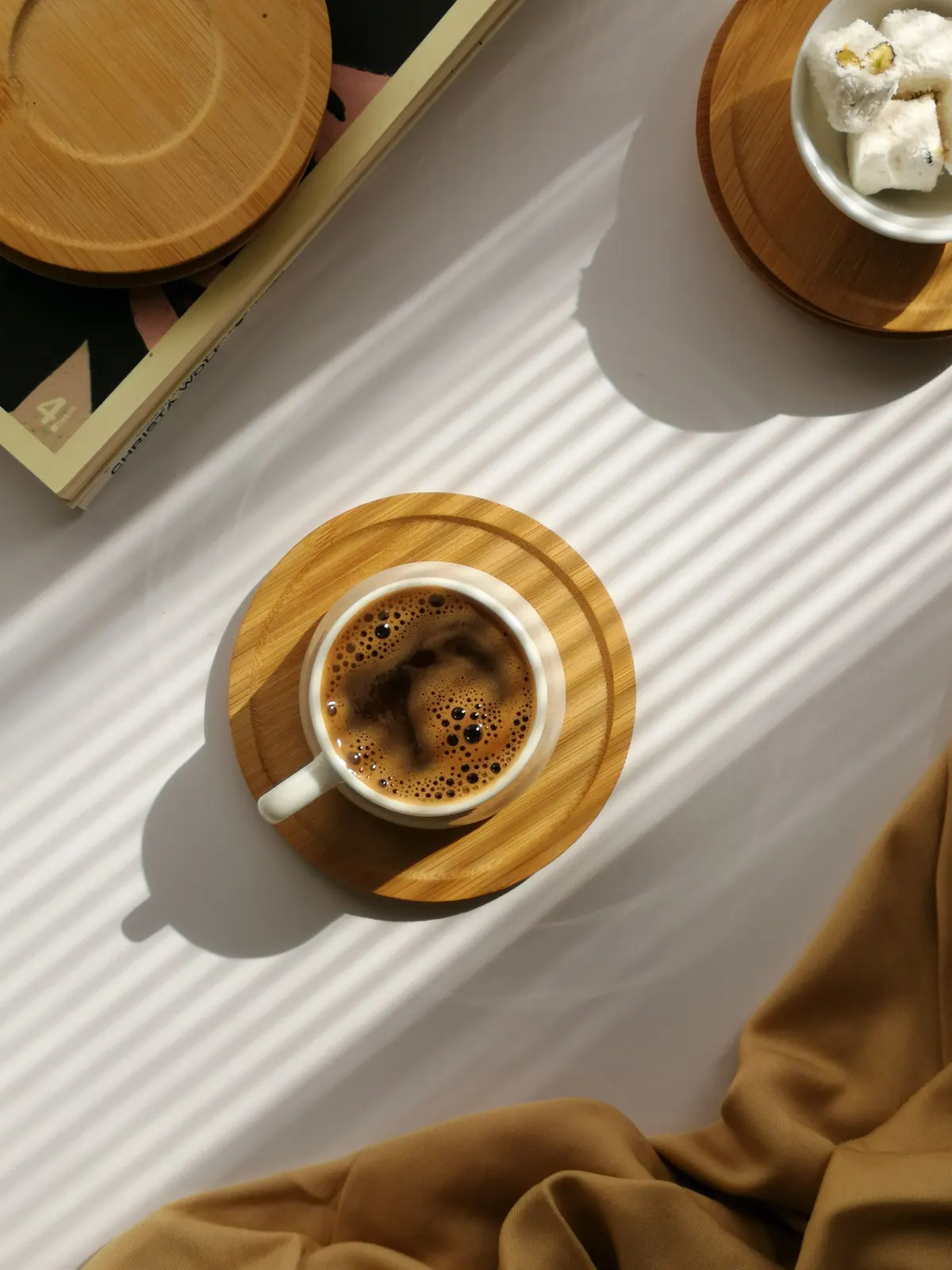 Coffee on a wooden coaster in a patch of sunlight