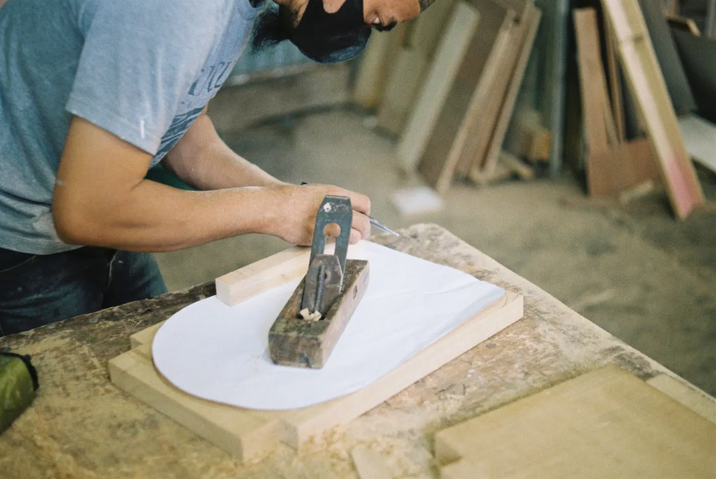 A hand plane being pushed along a board in daylight