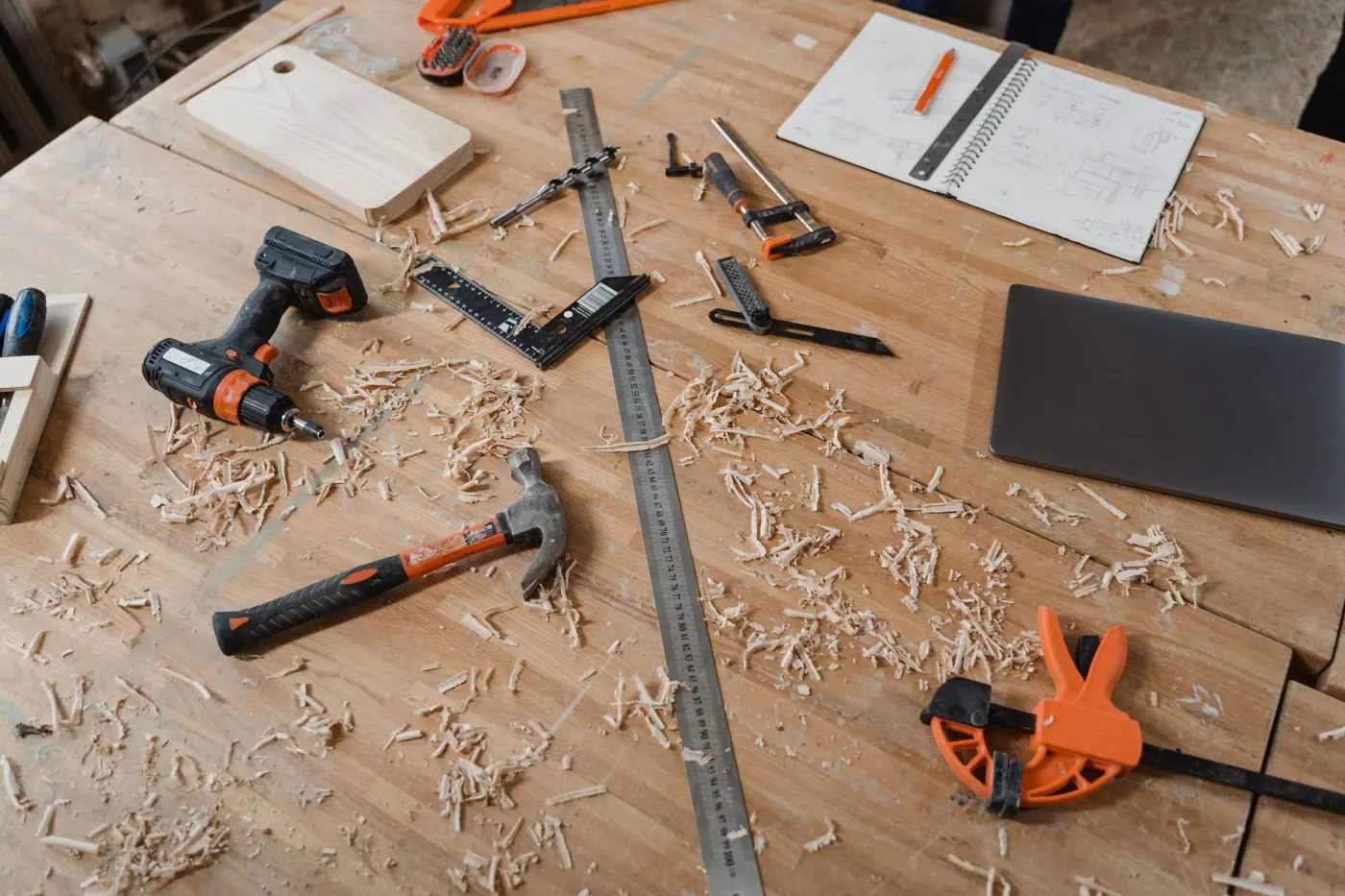 A workbench with a sketchbook, tools and shavings